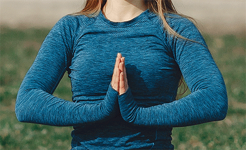 TouchLife-massage-Achtsamkeitsmassage-blog Eine Frau grüßt mit dem Namaste - Fried sei mir dir Grußzeichen.