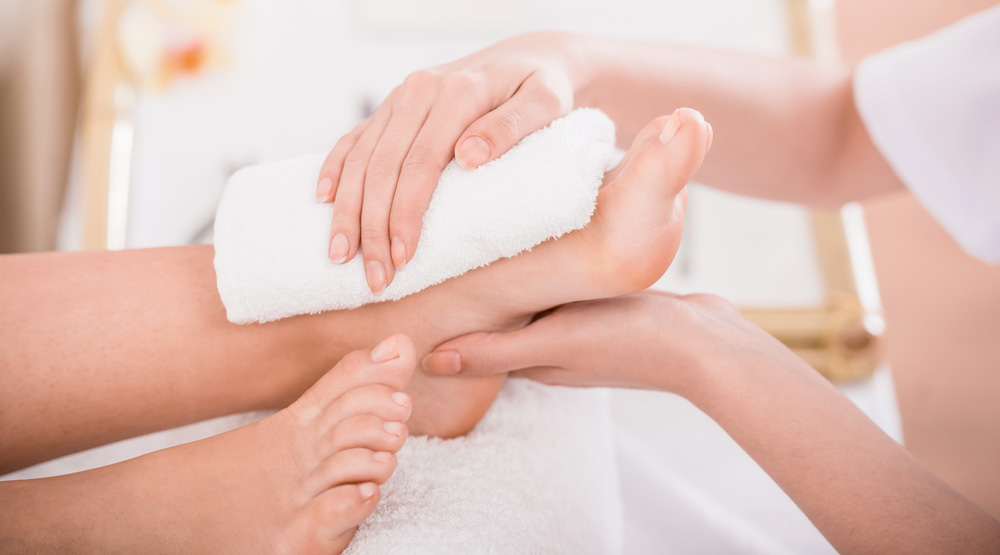 Fußpflege, Fußmassage, Entspannung für die Füße Fußpflegerin behandelt Füße