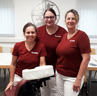 Drei TouchLife Massagepraktikerinnen mit Massagestuhl